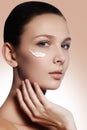 Beautiful face of young woman with cosmetic cream on a cheek. Sk Royalty Free Stock Photo