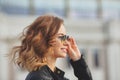 Beautiful face of young woman in round glasses and in black leather jacket