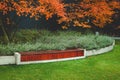 Beautiful fall background. Bench, leaves, lavender, dark wall. No people