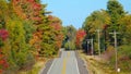 Fall colored forest surrounds the concrete road running through New Hampshire. Royalty Free Stock Photo