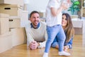 Beautiful famiily with kid lying down at new home around cardboard boxes