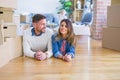 Beautiful famiily with kid lying down at new home around cardboard boxes