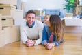 Beautiful famiily with kid lying down at new home around cardboard boxes