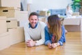 Beautiful famiily with kid lying down at new home around cardboard boxes