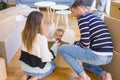 Beautiful famiily, kid playing with his parents riding cardboard fanny box at new home