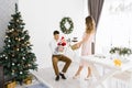 Beautiful family with baby celebrate New Year and celebrate Christmas in living room with Christmas tree. Mom gives a gift Royalty Free Stock Photo