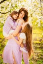 A family in a blossoming spring garden. Happy mom and two daughters. Royalty Free Stock Photo