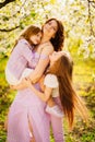 A family in a blossoming spring garden. Happy mom and two daughters. Royalty Free Stock Photo