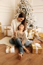 Beautiful family celebrating Christmas with decorated tree and presents Royalty Free Stock Photo