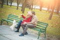 Beautiful family couple with white cute Maltese dog spending time in autumn park. Royalty Free Stock Photo