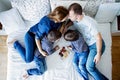 Beautiful family of four, lying on the bed, eating strawberries Royalty Free Stock Photo