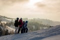 Beautiful family with kids, skiing in a scenery area in Austrian Alps on sunset, enjoying the view