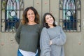 Beautiful family of mother and daughter smiling cheerful, two happy women together leaning on each other as woman power Royalty Free Stock Photo