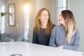 Beautiful family of mother and daughter together at home looking away to side with smile on face, natural expression Royalty Free Stock Photo