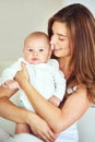 Beautiful family portrait of mother and baby boy hugging, bonding at home, carefree and loving. Smiling, cheerful parent Royalty Free Stock Photo