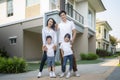 Beautiful family portrait smiling outside their new house with a key, this photo canuse for family Royalty Free Stock Photo