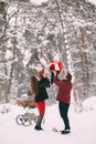 A beautiful family with retro pram walks through the winter snowy forest