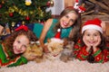 Beautiful family wearing a christmas clothes, hugging her cats, the curly girl with a red tie in her hair while the Royalty Free Stock Photo