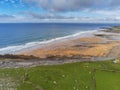 Beautiful Fanore beach, county Clare, Ireland. Aerial view. Blue Atlantic ocean water, yellow sand. People swimming and surfing. C