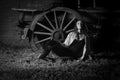 Beautiful farm girl leaning against old wagon