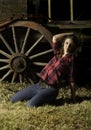 Beautiful farm girl posing in front of old wagon