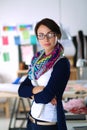 Beautiful fashion designer standing in studio