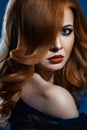 Beautiful fashion girl with long wavy red brown hair. fair-haired model with curly hairstyle and fashionable smoky makeup . Royalty Free Stock Photo