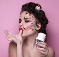 Beautiful fashion girl with luxury professional makeup and funny emoji stickers glued on the face. Young woman with cupcake.