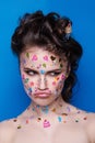 Beautiful fashion girl with luxury professional makeup and funny emoji stickers glued on the face.