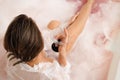 Beautiful Fashion model girl taking milk pink bath, spa and skin care concept. Beauty young Woman with martini glass Royalty Free Stock Photo