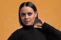 Beautiful fashion model with smokey makeup and big eyes showing blue earrings, lady wearing the black polo neck at the photo Royalty Free Stock Photo