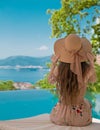 Beautiful Fashion Woman in beach hat enjoying sea view by swimming pool on luxury tropical resort. Exotic Paradise. Royalty Free Stock Photo