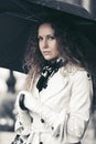 Beautiful fashion woman in white trench coat walking in city street Royalty Free Stock Photo