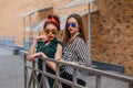 Beautiful fashion women posing. Trendy lifestyle urban portrait on city background. Girls wearing in style clothes and accessories