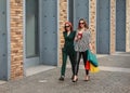 Beautiful fashion women with shopping bags. Trendy lifestyle urban portrait on city background Royalty Free Stock Photo