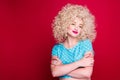 Beautiful fashionable blonde girl in retro style with voluminous curly hairstyle, in a blue polka dot blouse on a red background Royalty Free Stock Photo