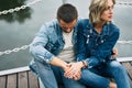 Beautiful fashionable couple posing on river bridge wearing denim jeans Royalty Free Stock Photo