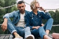 Beautiful fashionable couple posing on river bridge