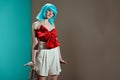 beautiful fashionable girl in blue wig posing and looking away Royalty Free Stock Photo