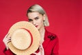 beautiful fashionable girl in red jacket with boutonniere and straw hat, Royalty Free Stock Photo