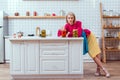 beautiful fashionable housewife with cans of pickled vegetables on counter Royalty Free Stock Photo