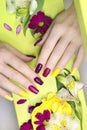 Beautiful fashionable multi-colored manicure with matte and glossy nail Polish colors with decorative small flowers