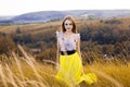 Beautiful fashionable pretty gorgeous girl in dress on the flowers field. Nice girl with wreath of flowers on her head and bouquet Royalty Free Stock Photo