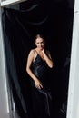 Beautiful fashionable slender woman in black silk evening dress