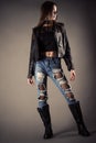 Beautiful fashionable teenager girl in leather jacket and torn jeans Royalty Free Stock Photo