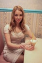 Beautiful fashionable woman girl blond in the room in a nice dress drink a coktail and smile