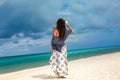 Beautiful fashionable woman walking on the beach with frangipani flower Royalty Free Stock Photo
