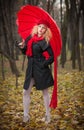 Beautiful fashionable young girl with red umbrella , red cap and red scarf in the park Royalty Free Stock Photo