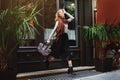 Beautiful fashionable young woman running with bag. City lifestyle. Female fashion. Full body portrait Royalty Free Stock Photo