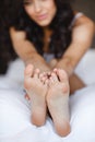 Beautiful feet, lying in the bed of a young woman Royalty Free Stock Photo